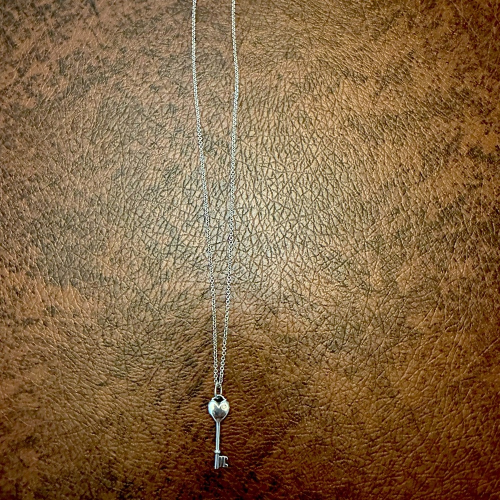 Tiffany’s sterling silver mini heart key with small diamond on a 16” chain.